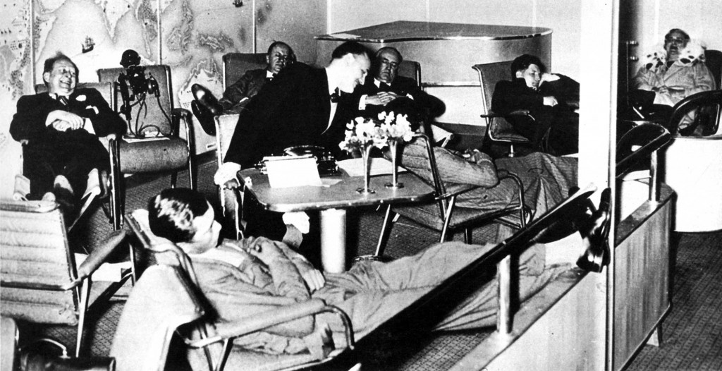 Louis Lochner (smiling, far left) in Hindenburg's lounge during its first flight to North America