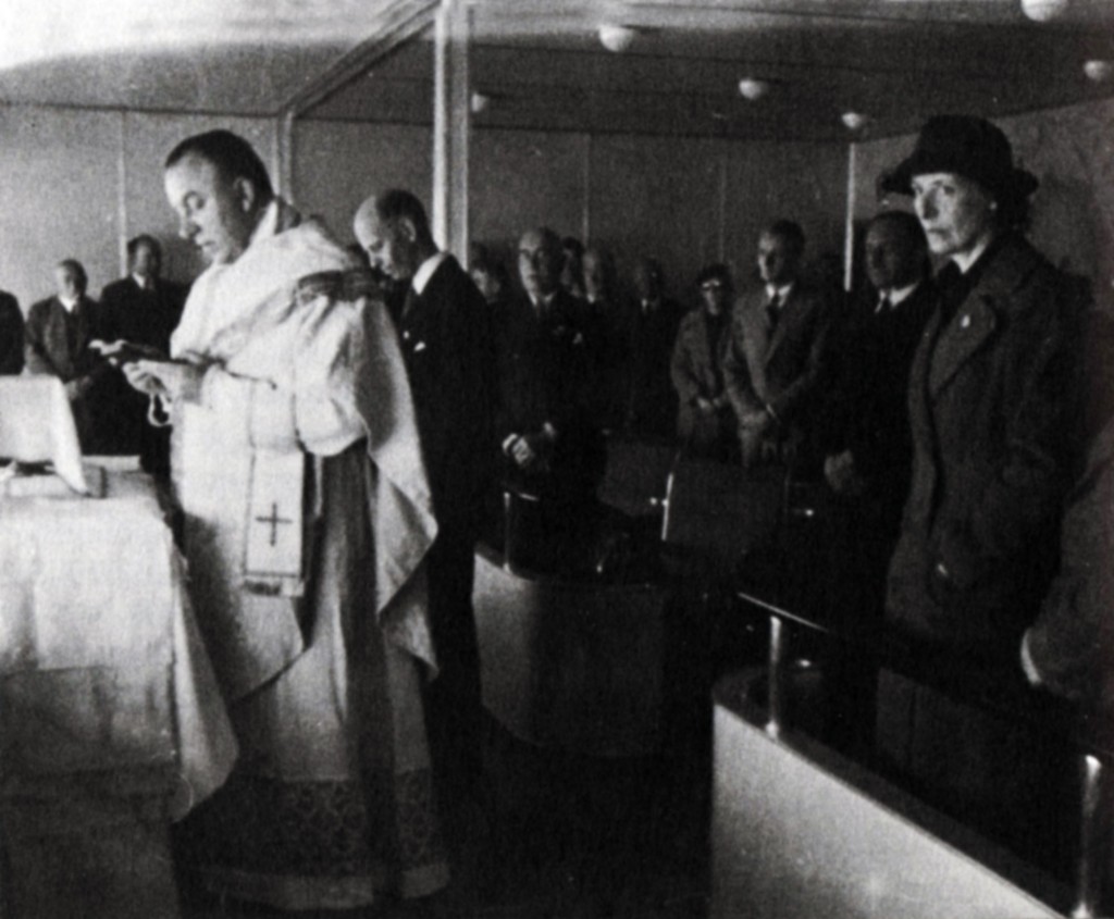 Father Paul Schulte leading the world's first aerial mass. ("First Flighter" Clara Adams at right.)